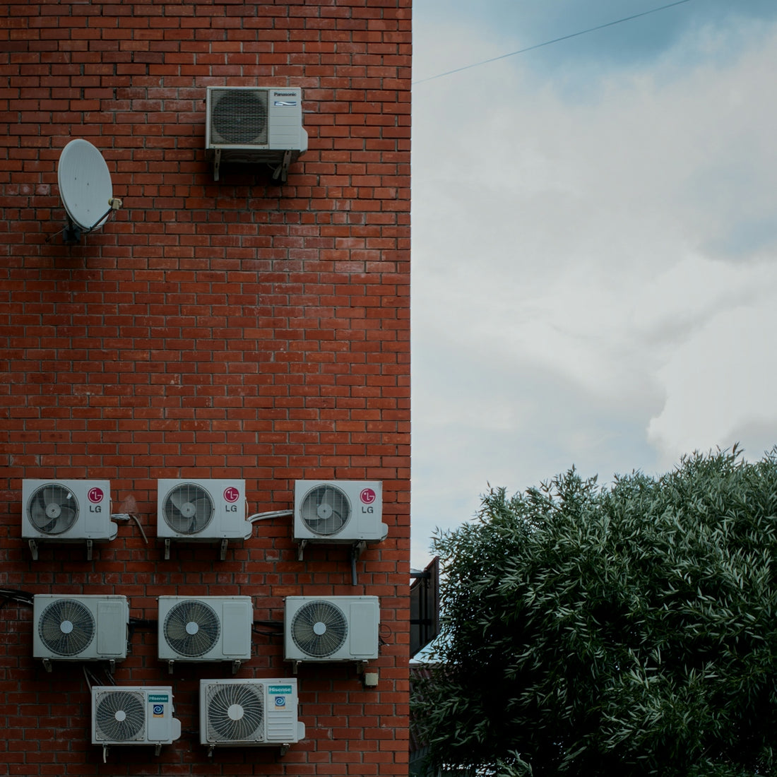 a brick wall with a bunch of air conditioners on it