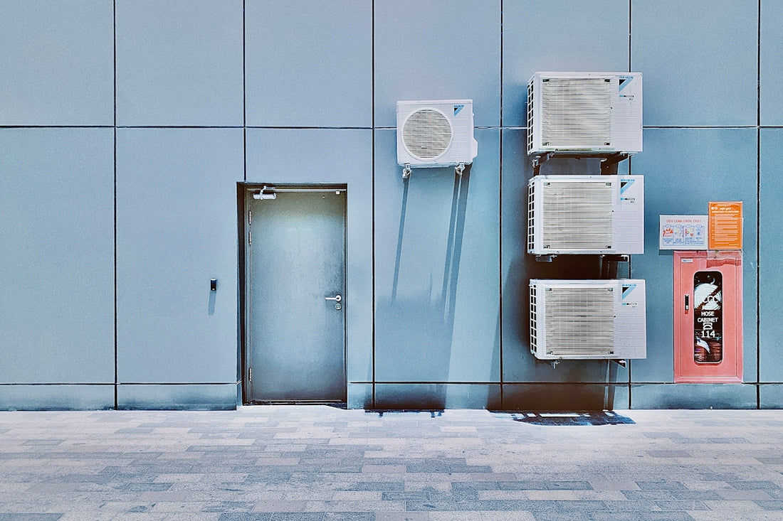 a couple of air conditioners sitting on the side of a building