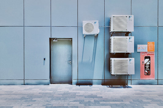 a couple of air conditioners sitting on the side of a building