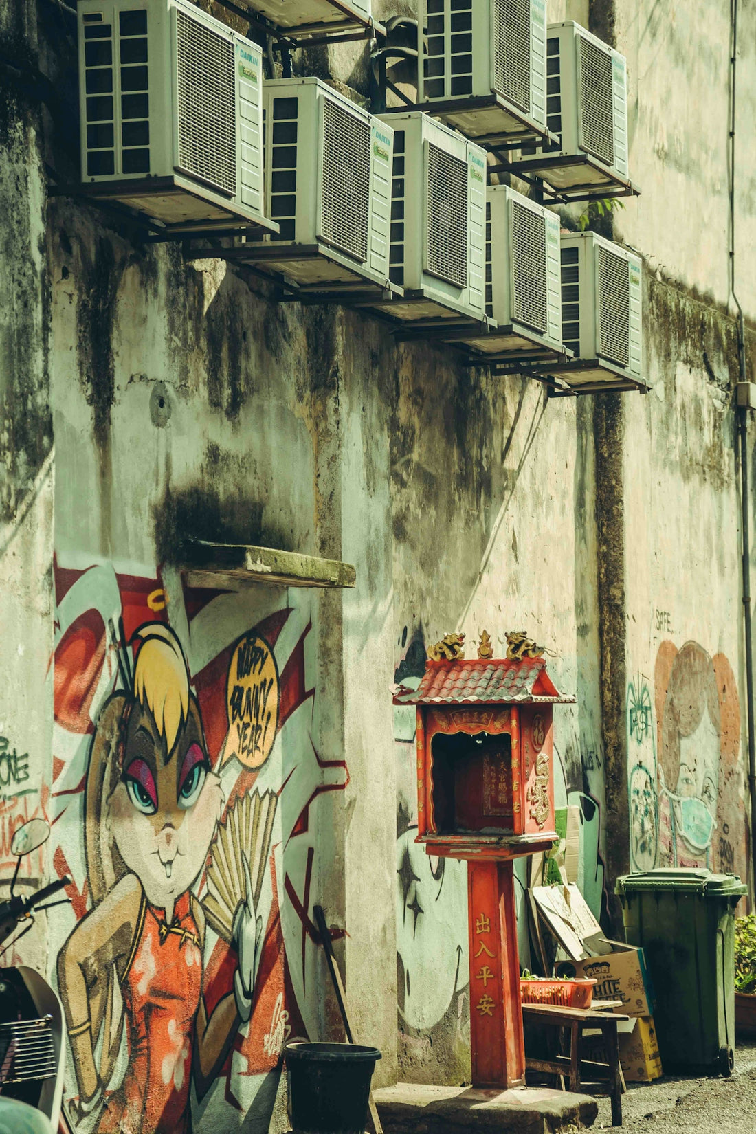 Air conditioners line a grungy alleyway's walls.