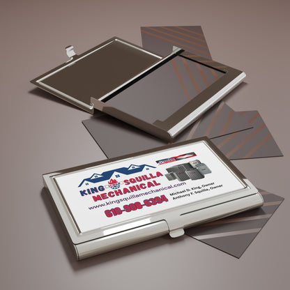 Business card holder with a King Squilla Mechanical business card on a reflective surface.